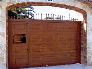 corredera con cuarterones y puerta peatonal inscrita